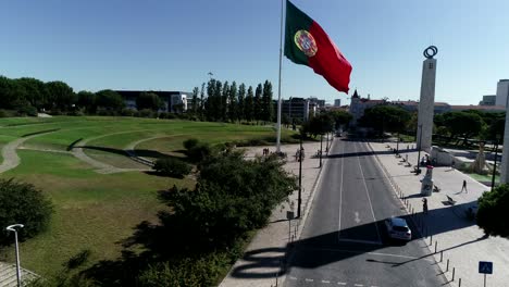 Riesige-Portugiesische-Flagge,-Die-Sich-In-Der-Luftaufnahme-Der-Portugiesischen-Hauptstadt-Windet