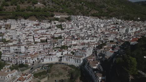 Mijas,-white-buildings-nestled-against-a-mountain-backdrop-in-Malaga,-Spain,-aerial-view