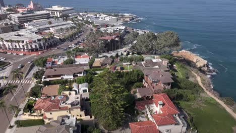 Aerial-over-beachfront-neighborhood-in-La-Jolla-approaching-beautiful-scenic-ocean-coast