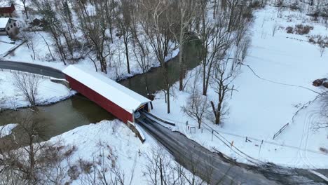 Red-covered-bridge-in-winter-snow-with-cars