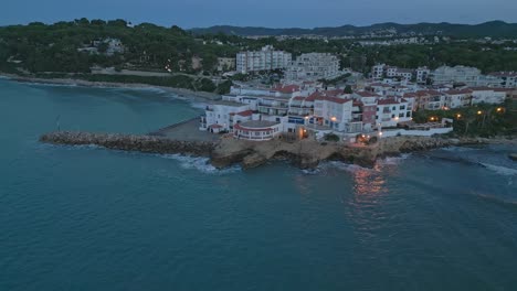Roc-de-Sant-Gaietà-on-Costa-Dorada-during-twilight,-quaint-coastal-village,-aerial-view
