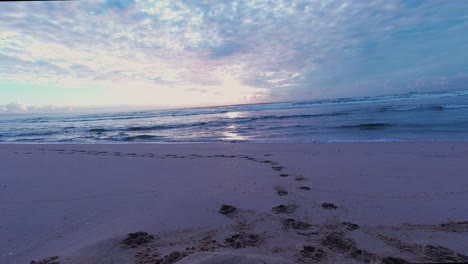 Rotierende,-Farbenfrohe-Zeitrafferaufnahme-Des-Sonnenaufgangs-Am-Strand,-Hereinbrechende-Wellen,-Herausziehende-Wolken