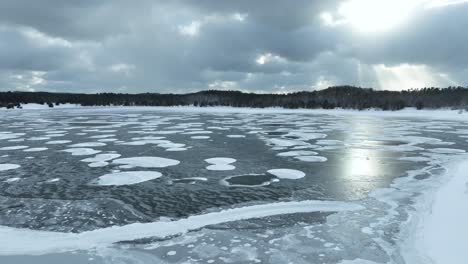 Reverse-track-over-a-frozen-lake-with-gorgeous-cloud-cover-and-light