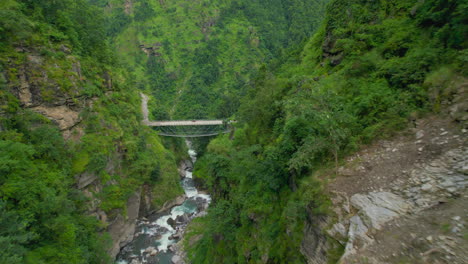 Landschaft-Von-Nepal,-Fluss,-Der-Zwischen-Hügeln,-Bergrücken,-Grüner-Umgebung,-Klippen,-Bäumen-Und-Brücken-Fließt