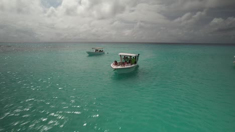 Türkisfarbenes-Wasser-Mit-Booten-Und-Schwimmern-In-Los-Roques,-Venezuela,-An-Einem-Sonnigen-Tag,-Luftaufnahme