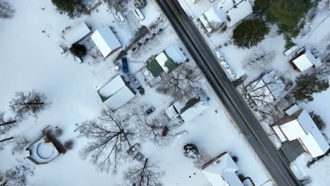 Top-down-diagonal-view-of-snowy-road-and-street-with-homes-and-houses