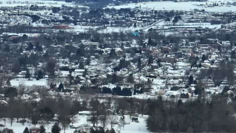 Long-zoom-of-dense-housing-in-town-in-USA-covered-in-winter-snow