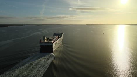 Cargo-ship-sailing-at-sunrise-on-calm-waters-on-Carlingford-Lough-near-Dundalk,-County-Louth,-Ireland,-aerial-view