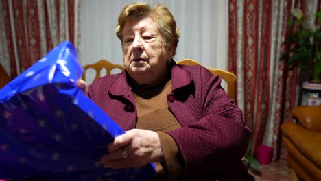 Elderly-woman-opens-birthday-present-in-retirement-home