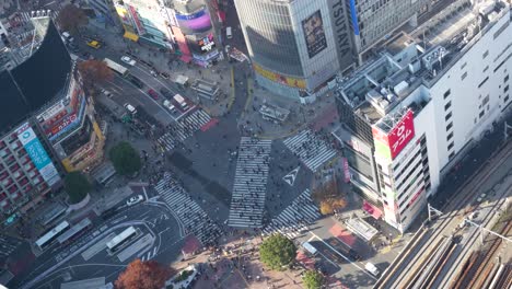 Shibuya-Crossing,-Tokyo-with-pedestrians-and-traffic,-daylight,-aerial-view