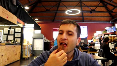 Hombre-Comiendo-Deliciosa-Croqueta-De-Bacalao-En-El-Mercado-De-Beira-Mar,-Porto