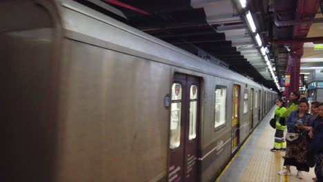 Una-Línea-De-Tren-Subterráneo-Llega-A-La-Estación-De-Metro-Con-Una-Joven-Latina-Local-Caminando