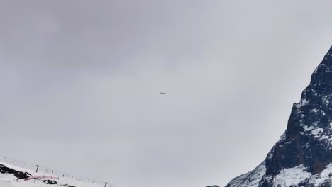 Schweizer-Bergrettungshubschrauber-Fliegt-über-Verschneites-Skigebiet