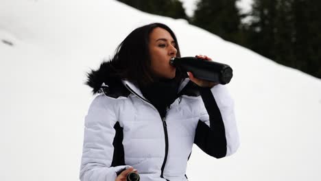 Girl-in-chilly-Switzerland-environment,-open-thermos-bottle-and-drink-warm-tea