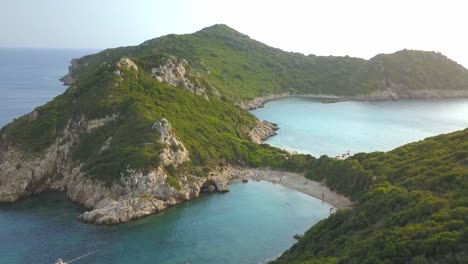 Porto-Timoni-bay-Corfu,-sun-sea-and-sand-Greek-island-holiday-AERIAL-FLYOVER