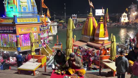 pov-shot-A-lot-of-people-are-sitting-on-the-bank-of-river-Ganga-eating-prasad