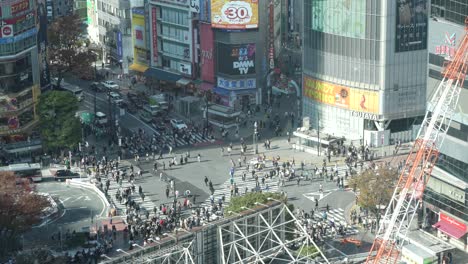 Shibuya-Crossing-in-Japan,-bustling-with-pedestrians,-aerial-view