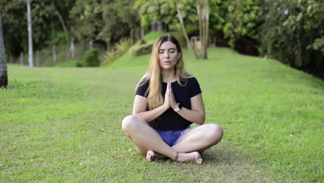 Woman-prays-and-meditates-in-green-field