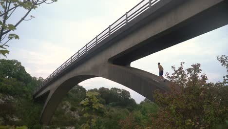 Mann-Klettert-Alleine-Auf-Eine-Brücke
