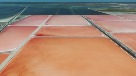 Scenic-aerial-view-of-Albanian-sea-salt-farm-shallow-solar-evaporation-ponds