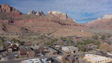 Springdale-town-and-colorful-mountains-near-Zion-National-Park,-Utah,-USA,-drone-approach-towards-Pioneer-Lodge-Motel