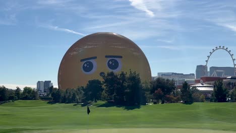 The-Las-Vegas-Sphere-illuminated-with-emoji-faces-as-seen-from-the-Wynn-Golf-Course,-static-shot