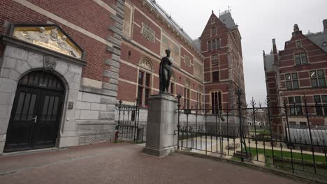 Side-building-exterior-view-with-statue-of-the-Rijksmuseum-in-Amsterdam