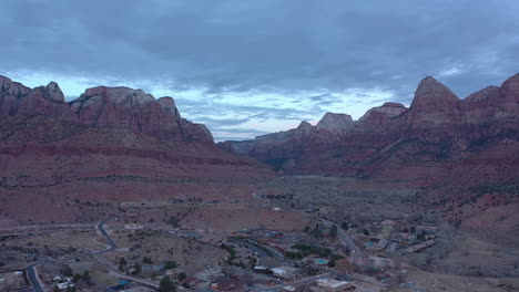 Wide-aerial-shot-of-Springdale-town-and-colorful-mountains-near-Zion-National-Park,-Utah,-USA,-shot-during-evening-blue-hour