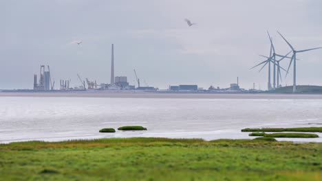 Eine-In-Dunst-Gehüllte-Stadt-Und-Rotierende-Windkraftanlagen-An-Der-Dänischen-Küste