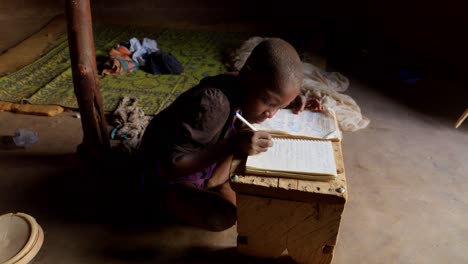 Innenansicht-Eines-Afrikanischen-Jungen,-Der-Bei-Tageslicht-Im-Dorf-Wulugu-In-Ghana-Lernt