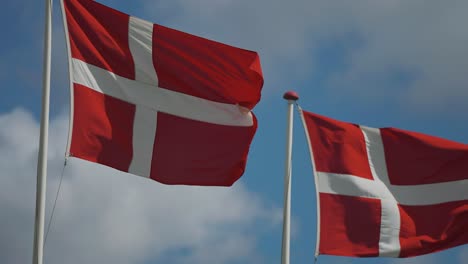 Two-Danish-flags-flutter-in-the-wind-in-the-slow-motion-video