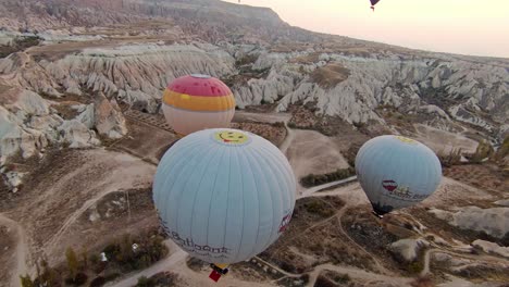 Vista-Matutina-De-Globos-Aerostáticos-Flotando-Sobre-El-Desierto-Y-Formaciones-Rocosas-En-Capadocia,-Turquía.