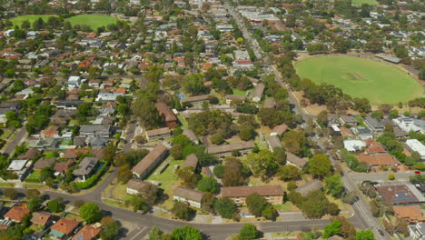 Aerial-view-revealing-suburban-houses-and-dynamic-traffic-flow-on-the-nearby-highway