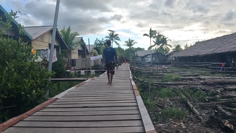 Indonesische-Dorfbewohner-Gehen-Auf-Holzdeck-In-Einem-Armen-Dorf-In-Der-Nähe-Von-Papua
