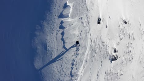 Aerial-top-down-view-of-person-walking-on-new-snow