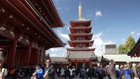In-the-daytime,-a-lively-scene-unfolds-with-people-gathered-in-front-of-Tokyo's-Sensoji-Temple-and-its-Five-Storied-Pagoda