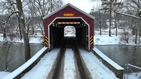 Aerial-flyover-of-a-snowy-covered-bridge