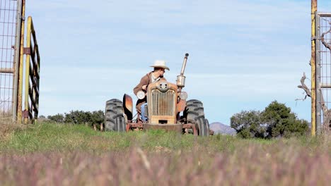 Rancher-Towing-Harrow-Through-Fence-on-Farming-Field