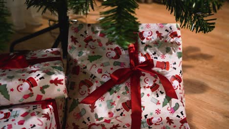 Aufnahme-Verpackter-Kleiner-Geschenke-Unter-Einem-Geschmückten-Plastikweihnachtsbaum-Im-Haus,-Schwenk