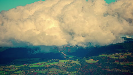 Massive-rolling-cloud-massing-above-countryside-landscape,-timelapse