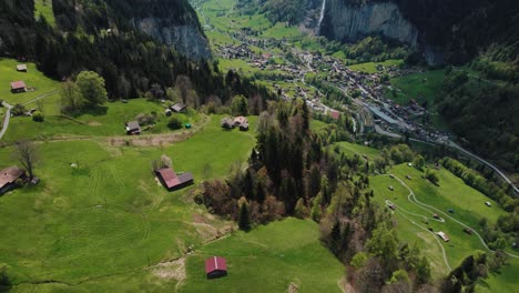 drone-shot-revealing-Lauterbrunnen-valley-and-Staubbach-waterfall-with-the-snow-capped-mountain-in-the-background-from-Wengen-village