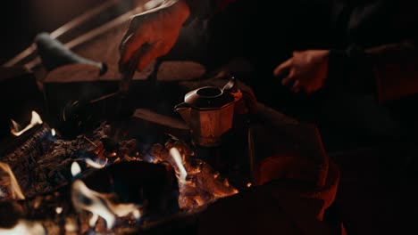 Campfire-Coffee:-A-young-man-with-his-leg-in-cast-puts-his-beat-up-moka-pot-onto-the-ember-of-his-campfire