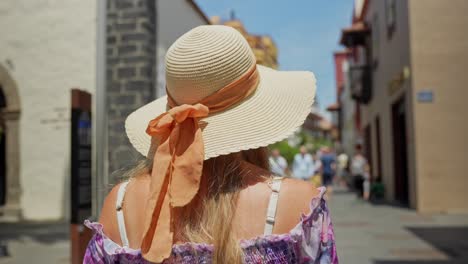Beautiful-woman-wearing-straw-hat-while-walking-in-Puerto-de-la-Cruz-city