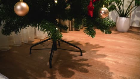 Foto-De-Colocar-Pequeños-Regalos-Envueltos-Debajo-De-Un-árbol-De-Navidad-De-Plástico-Decorado-En-La-Casa