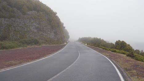Vista-De-Una-Carretera-Tallada-En-Las-Montañas-De-La-Isla-De-Madeira-Durante-El-Invierno,-Niebla-Que-Cubre-Una-Sección-De-La-Carretera