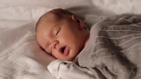 Close-up-of-a-newborn-baby-boy's-face-while-sleeping-and-breathing-heavily