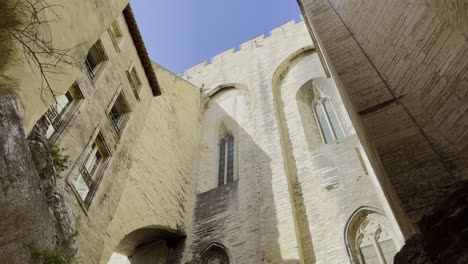 Hoher-Seitenvorbau-Einer-Kirche-In-Avignon-Aus-Sandstein-Bei-Gutem-Wetter-Mit-Einer-Mauer-Daneben