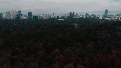 Drone-footage-over-Mexico-City,-flying-towards-the-skyline-and-over-Chapultepec-Park,-showcasing-urban-beauty-and-green-spaces