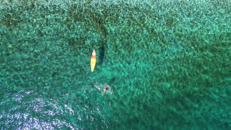 Aerial-top-down-drone-shot-of-a-paddle-boarders-in-turquoise-aegean-sea-,-beach-of-Andros,-Cyclades,-Greece