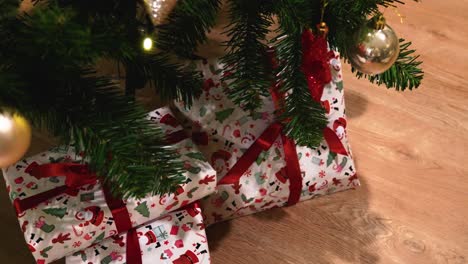Aufnahme-Verpackter-Kleiner-Geschenke-Unter-Einem-Geschmückten-Plastikweihnachtsbaum-Im-Haus,-Rotierende-Aufnahme